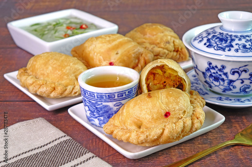 Curry puff. Chicken curry puff (or Karipap) is a snack of Southeast Asian origin. It is a small pie consisting of curry with chicken and potatoes in a deep-fried or baked.