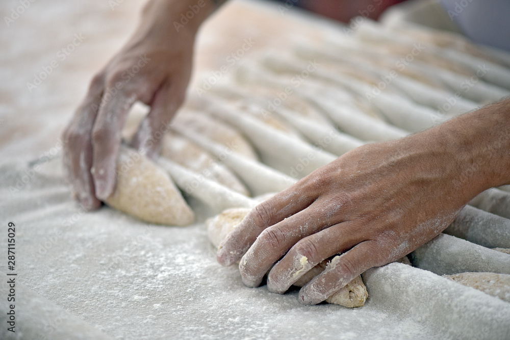 The baker shapes the bread to be baked