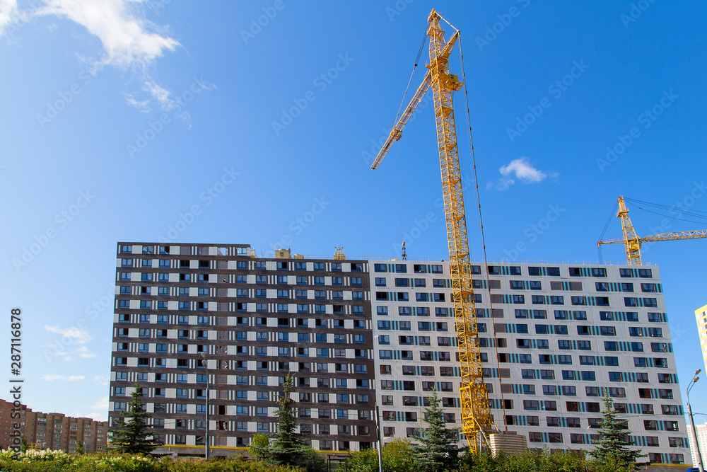 Cranes over the house under construction .Horizontally. Cranes over the house under construction .Horizontally.