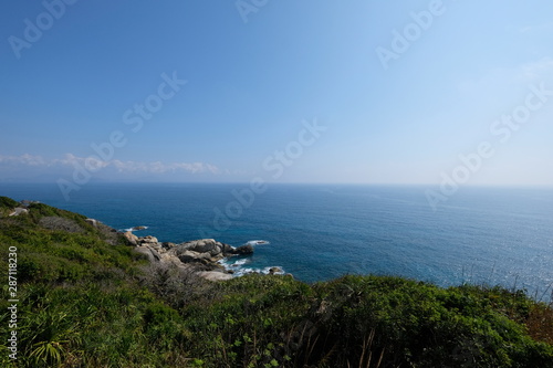 Wallpaper Mural sunny blue sky and sea horizon. fresh green grass and trees foreground. mountain slope of Wuzhizhou island in Sanya Hainan China.   Torontodigital.ca