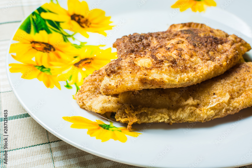 Fried tilapia fish fillets in plate on the kitchen table. Fried tilapia fish fillets in plate on the kitchen table.