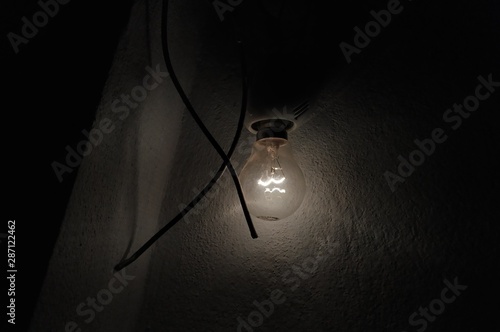Electric bulb glowing in a dark room
