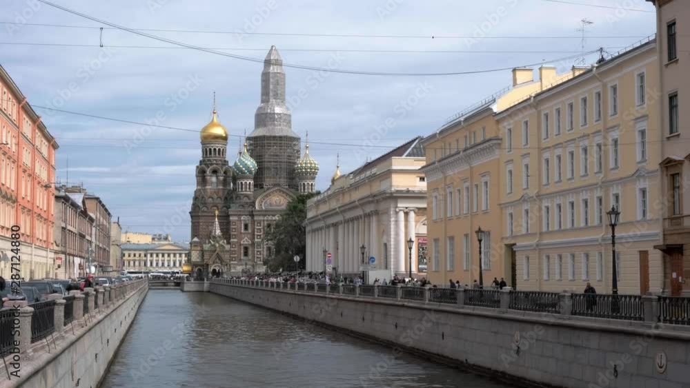 ST. PETERSBURG, RUSSIA - AUGUST 5, 2019: the Griboyedov Canal, in the background the Church of the Savior on Spilled Blood ST. PETERSBURG, RUSSIA - AUGUST 5, 2019: the Griboyedov Canal, in the background the Church of the Savior on Spilled Blood