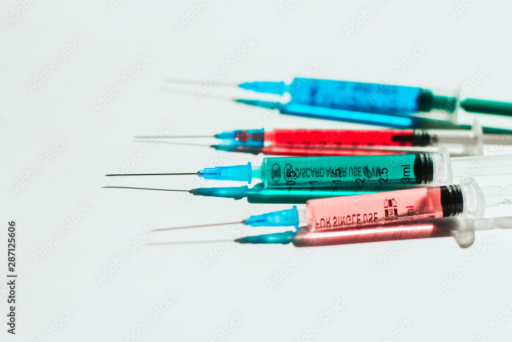 Obraz premium syringes with multicolored liquid on a white background.