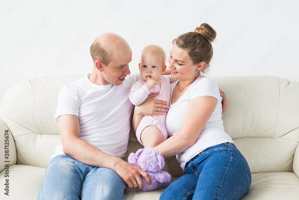 Proud mother and father smiling at their newborn baby daughter at home Proud mother and father smiling at their newborn baby daughter at home
