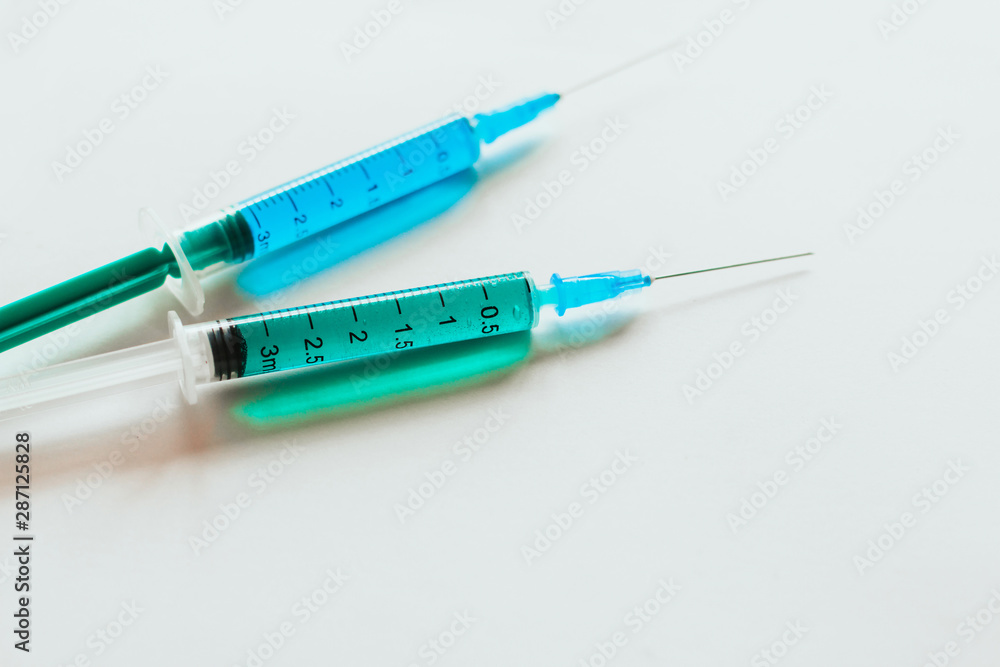 syringes with multicolored liquid on a white background. syringes with multicolored liquid on a white background.