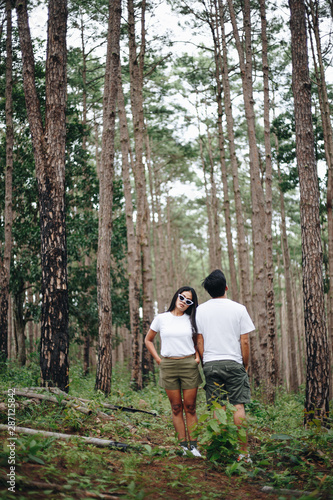 Man and Woman Asian tourists traveling in a pine forest, nature travel concept