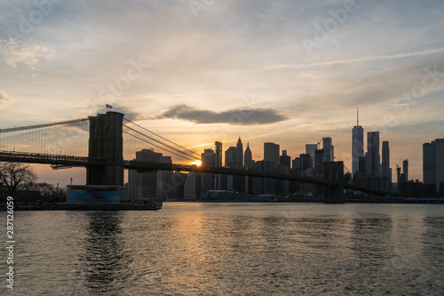 scene of New york Cityscape with Brooklyn Bridge over the east river at the sunset time, USA downtown skyline, Architecture and transportation concept