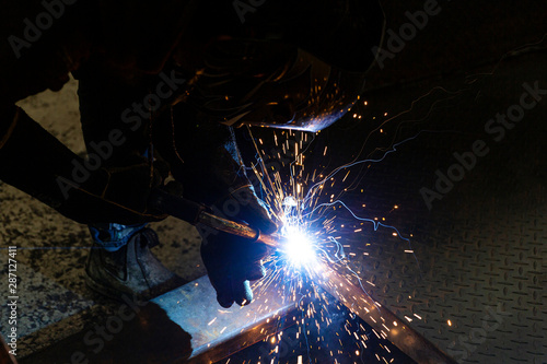 Metal worker welding customer order together.