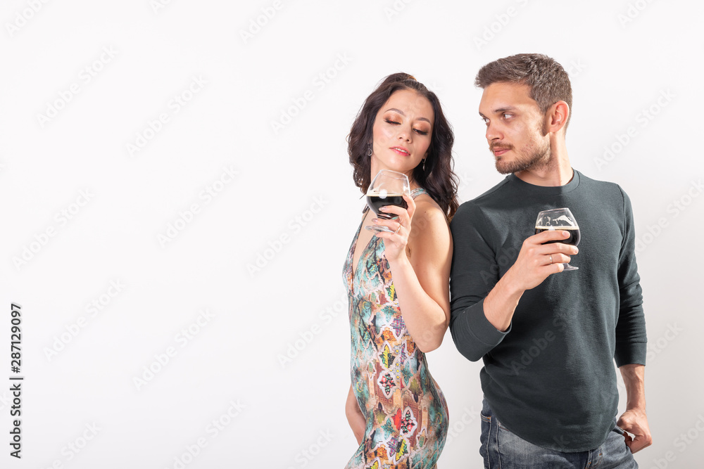 Man and woman are holding glasses of dark beer on white background with copy space. Oktoberfest concept. Man and woman are holding glasses of dark beer on white background with copy space. Oktoberfest concept.
