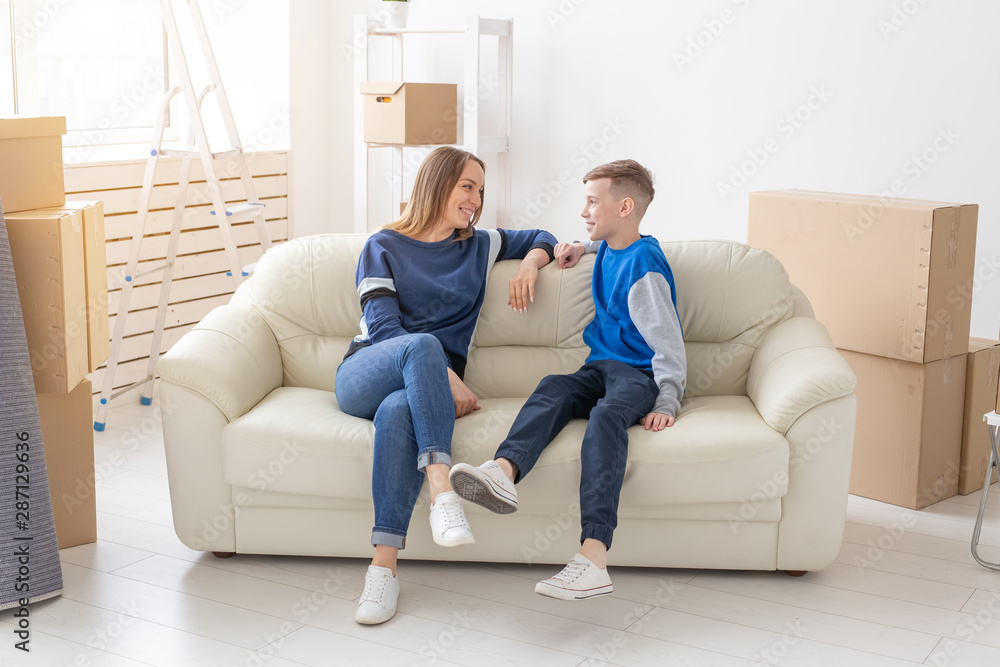 Satisfied happy caucasian single mother and son happily communicate discussing the design of the new apartment during the housewarming party. Satisfied happy caucasian single mother and son happily communicate discussing the design of the new apartment during the housewarming party.