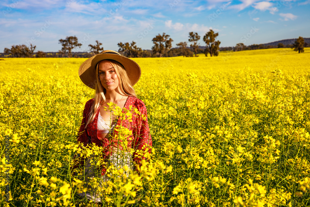 Happy young lady with straw hat in yellow Canola Field in Western Australia Happy young lady with straw hat in yellow Canola Field in Western Australia
