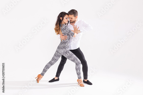 Passionate couple dancing social danse kizomba or bachata or semba or taraxia on white background with copy space