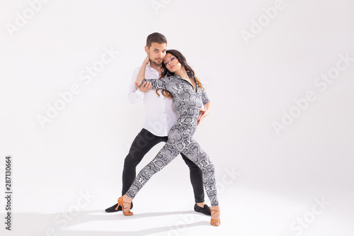 Social dance concept - Active happy adults dancing bachata or salsa together over white background with copy space