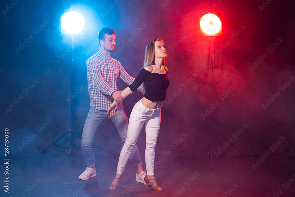 Social dance, kizomba, salsa, semba or zouk concept - a young couple dancing bachata and salsa at the disco