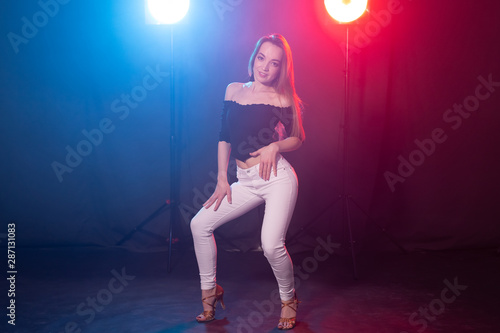 Fototapeta Naklejka Na Ścianę i Meble -  Nightlife and club concept - young woman dancing in the dark under the lights