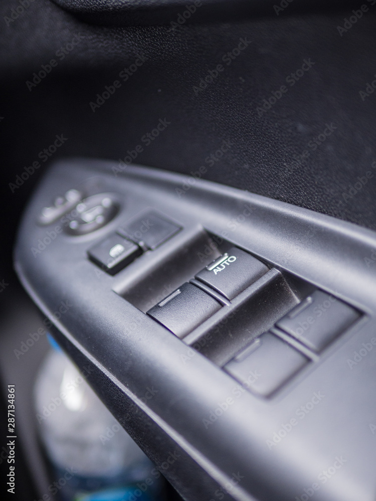 Close up car window control buttons.