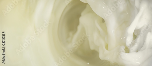 Splashes of liquid milk on a long horizontal background is macro © savelov