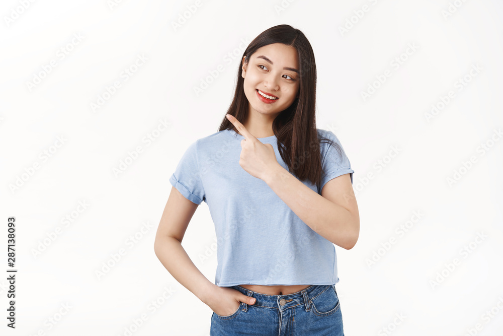 Interested curious pretty asian brunette girl student intrigued looking pointing left side copy space tilt head amused happy broad smile pick right good choice standing white background Interested curious pretty asian brunette girl student intrigued looking pointing left side copy space tilt head amused happy broad smile pick right good choice standing white background