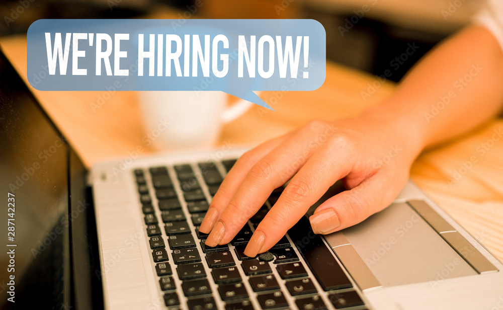 Word writing text We Re Hiring Now. Business photo showcasing recently employ someone or pay someone to do particular job woman laptop computer smartphone mug office supplies technological devices Word writing text We Re Hiring Now. Business photo showcasing recently employ someone or pay someone to do particular job woman laptop computer smartphone mug office supplies technological devices