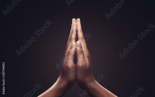Praying hands with faith in religion and belief in God on dark background. Power of hope or love and devotion. Namaste or Namaskar hands gesture.