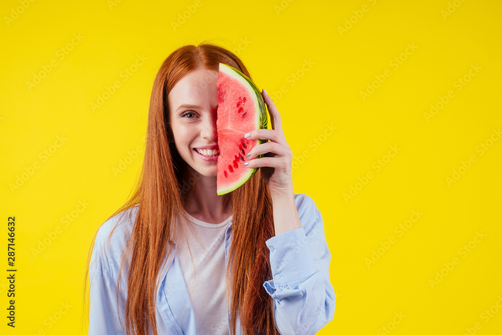 redhaired ginger girl with big piece of watermelon in studio yellow background.detox yoga concept redhaired ginger girl with big piece of watermelon in studio yellow background.detox yoga concept