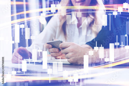 Candlestick chart in foreground. In background are business people with laptops, smartphones and other gadgets. Double exposure.