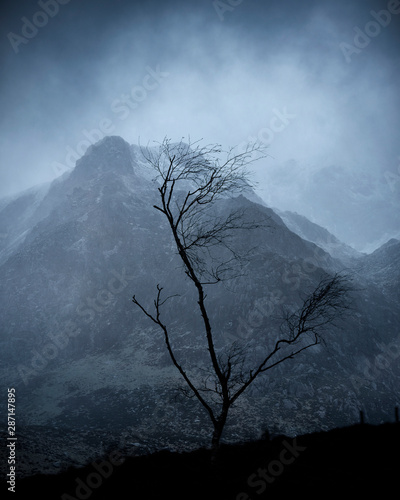 Stunning moody dramatic Winter landscape image of snowcapped Y Garn mountain in Snowdonia photo