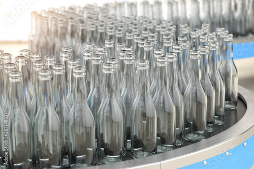 Slika na platnu Empty  glass bottles on conveyor belt in factory or glass manufacture