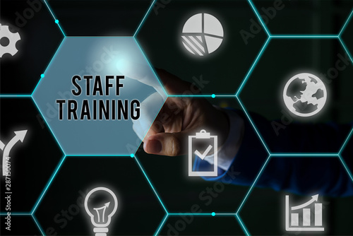 Text sign showing Staff Training. Business photo showcasing program that helps employees learn specific knowledge Male human wear formal work suit presenting presentation using smart device