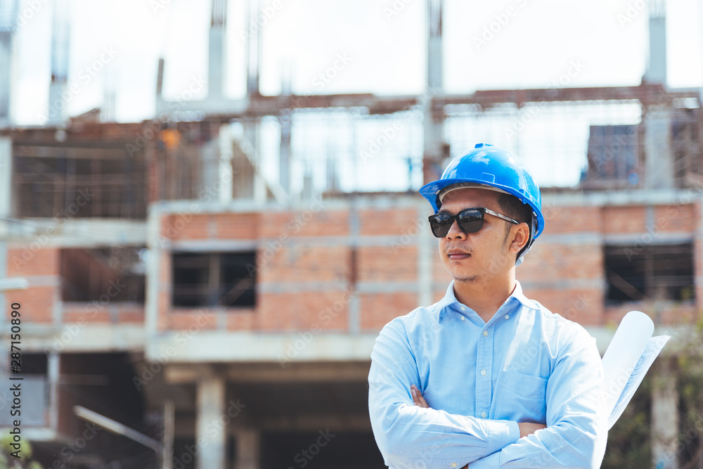Asian man architect wearing blue safety helmet checking working progress at construction site. Asian man architect wearing blue safety helmet checking working progress at construction site.