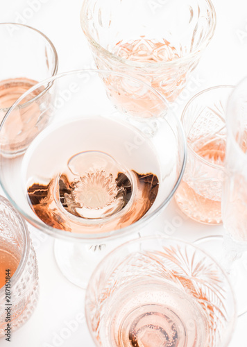 Sparkling rose wine in different glasses on white background