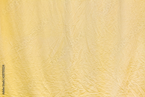 Crumpled soft light yellow bed linen surface