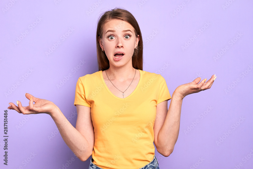 Stunned young female has clueless and puzzled face expression, doesnt know what to do with problem situation, stands with wide opened eyes and mouth, shruggs shoulders, feels confused. Stunned young female has clueless and puzzled face expression, doesnt know what to do with problem situation, stands with wide opened eyes and mouth, shruggs shoulders, feels confused.