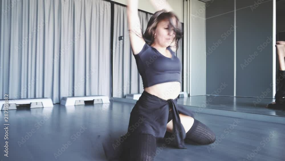 Russian girl is cool dancing in the studio. She is wearing long black knee-high socks and a black tank top. Russian girl is cool dancing in the studio. She is wearing long black knee-high socks and a black tank top.