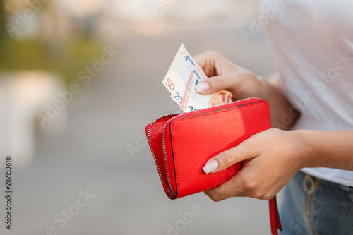 Female hands gets money from the wallet. Euro cash background.