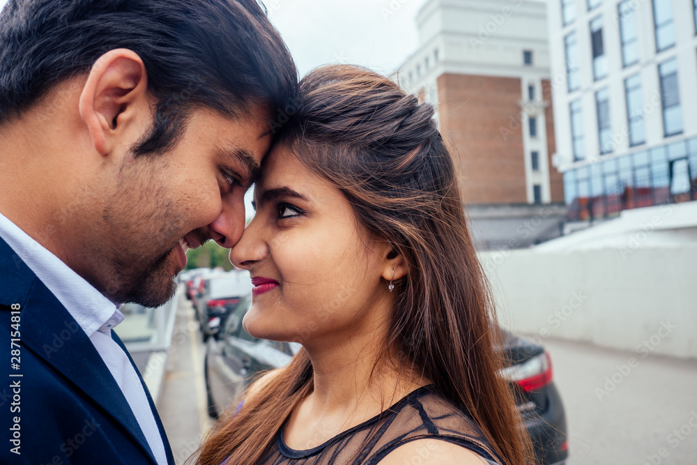 Naklejka premium indian woman in long evening blue dress spinding romantic time together with lover handsome boyfriend europe urban downtown city
