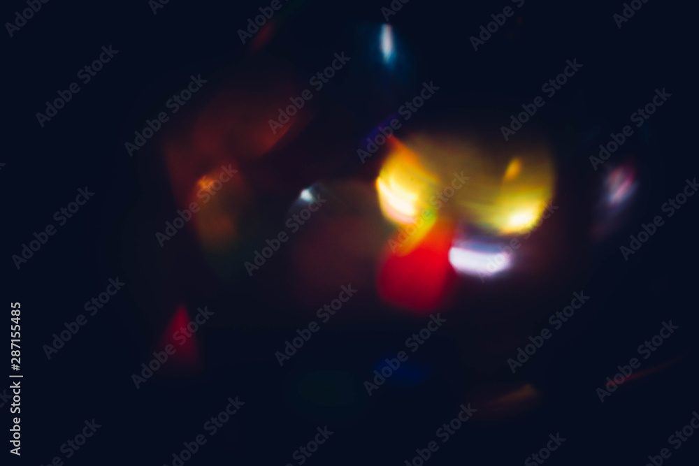 Multicolor bokeh lights. Defocused glowing spots. Lens flare. Dark abstract background. Multicolor bokeh lights. Defocused glowing spots. Lens flare. Dark abstract background.