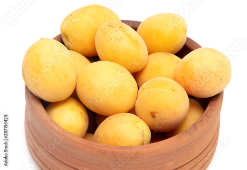 Ripe apricot in clay pot on a white background