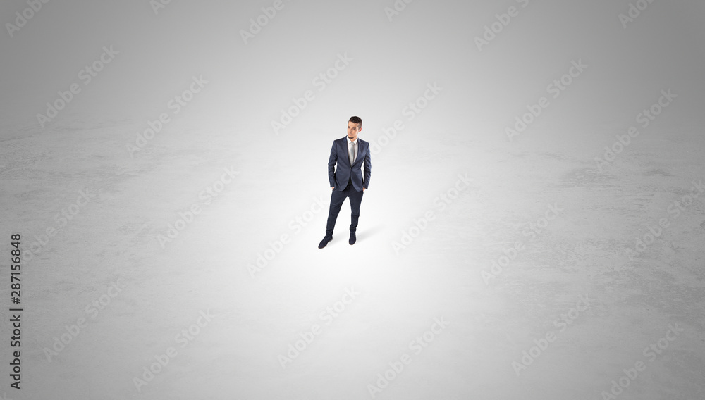 Young businessman standing alone in the middle of an empty space Young businessman standing alone in the middle of an empty space