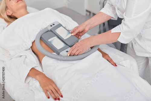 talented cosmetologist preparing patient for cryolipolysis process. close up cropped photo. new modern technology, beauty care