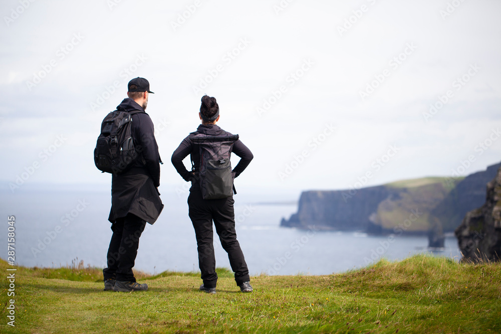 Hombre y mujer observando los acantilados de Moher en Irlanda Hombre y mujer observando los acantilados de Moher en Irlanda