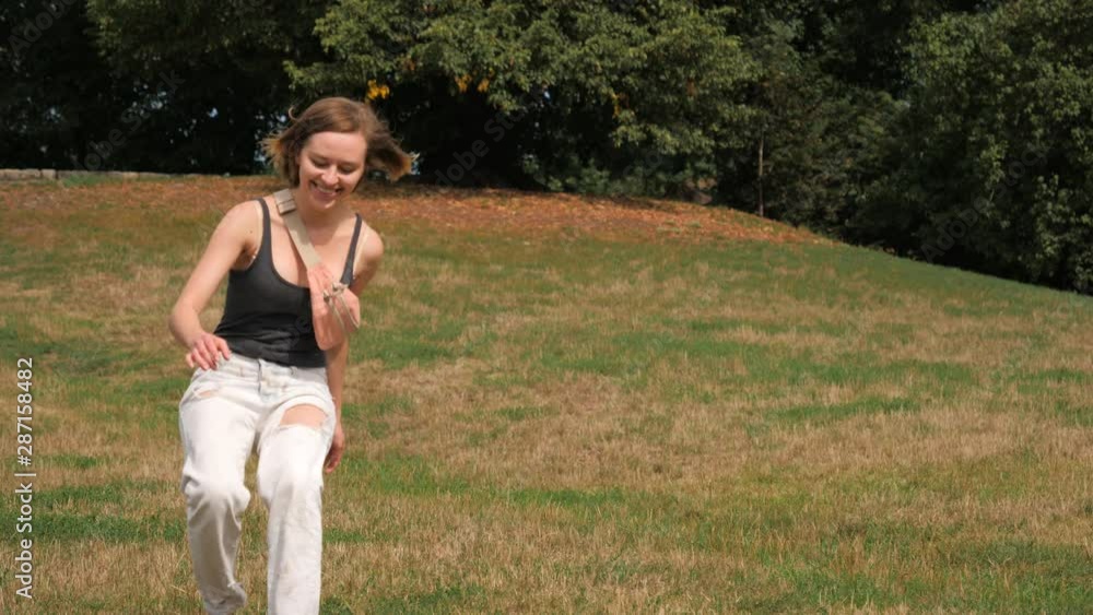 Young woman playing with her big white pet dog running chasing in a park Young woman playing with her big white pet dog running chasing in a park