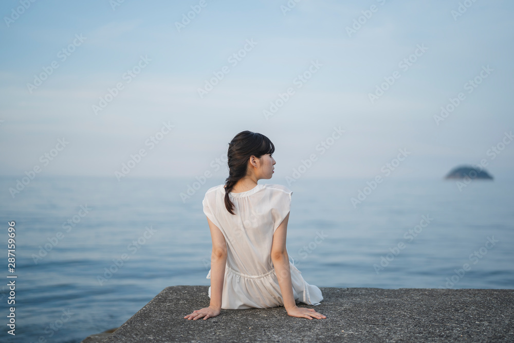 夕暮れの海の女性