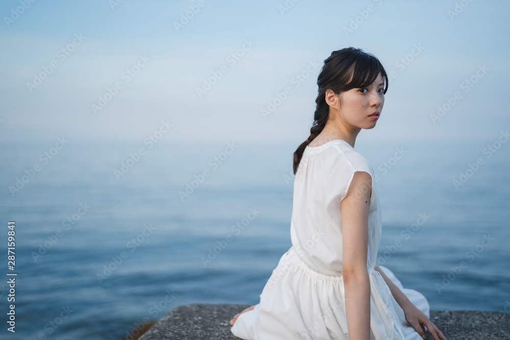 夕暮れの海の女性