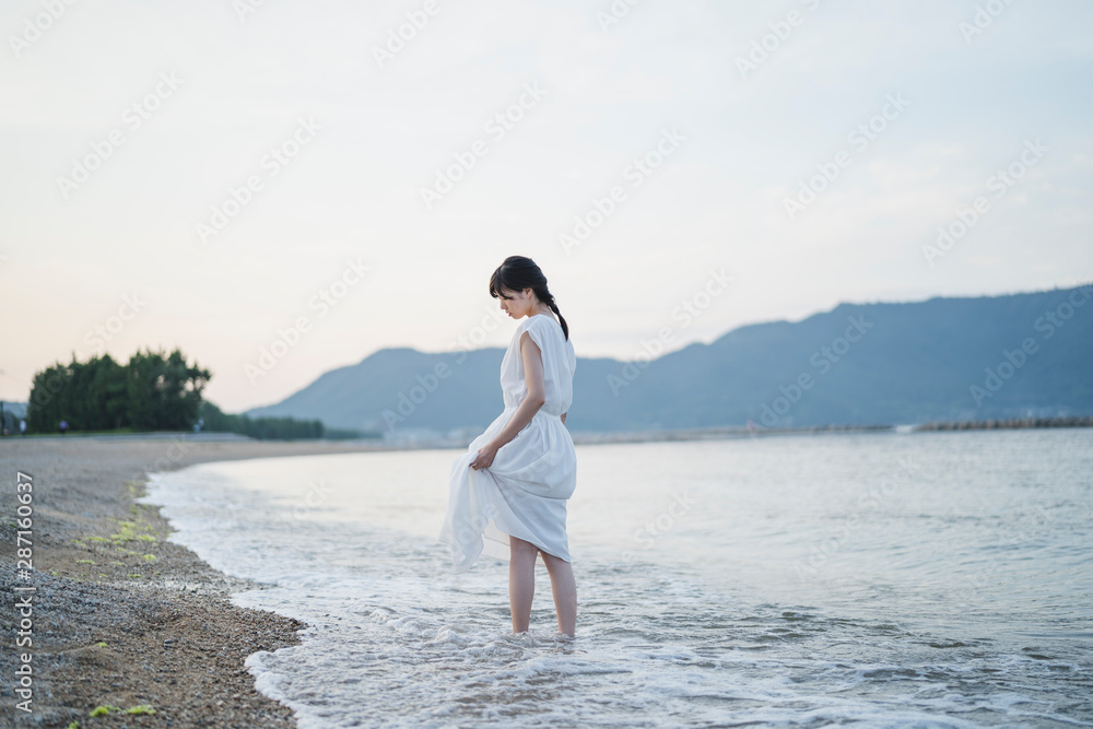 夕暮れの海の女性