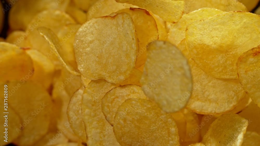 Super Slow Motion Shot of Potato Chips Flies After Being Exploded against Black Background, 1000fps. Super Slow Motion Shot of Potato Chips Flies After Being Exploded against Black Background, 1000fps.