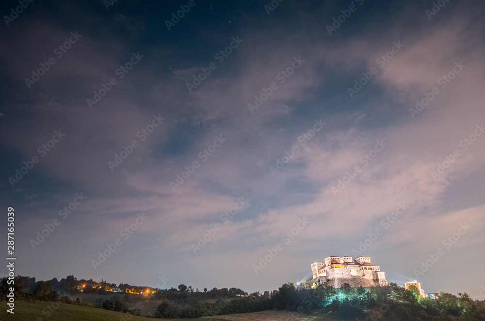 Il Castello di Torrechiara a Parma (Italia) sotto al cielo nuvoloso e stellato