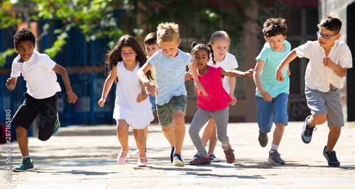 Happy kids running in race in the street and laughing outdoors