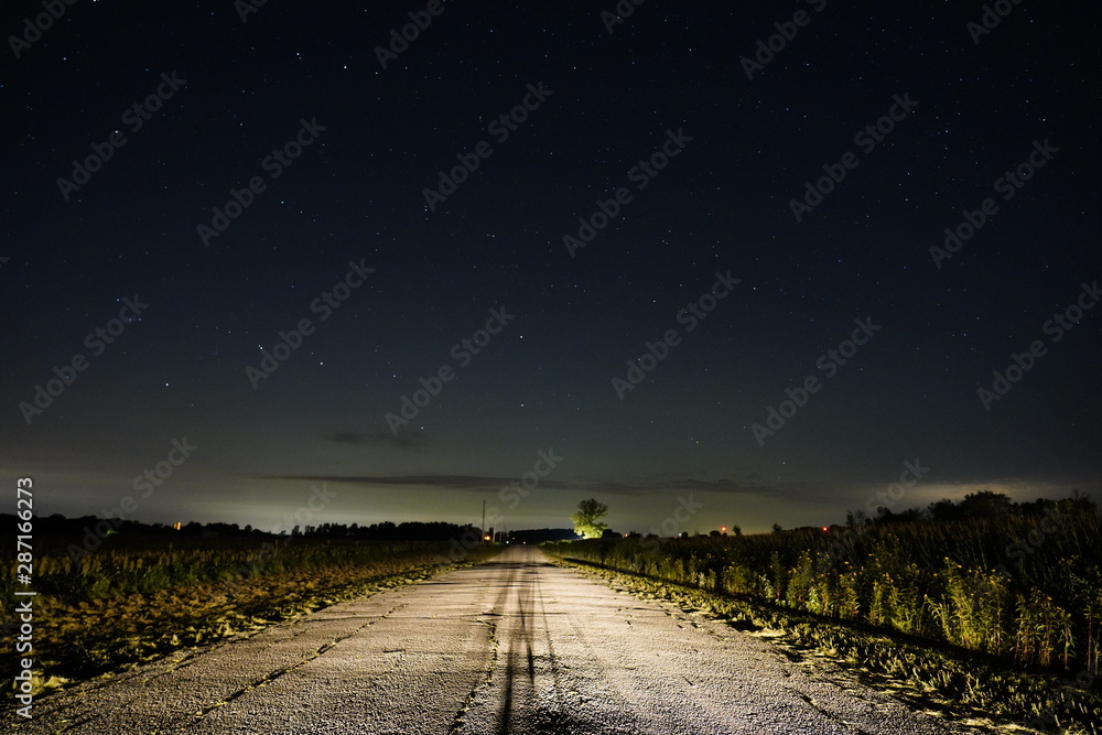 Road to New Hope. Country Road lite up at night by the starry sky